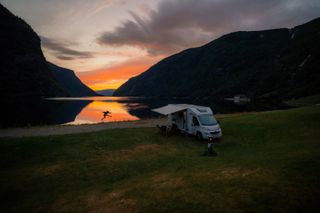 Camper an Bergsee bei buntem Sonnenuntergang in Norwegen